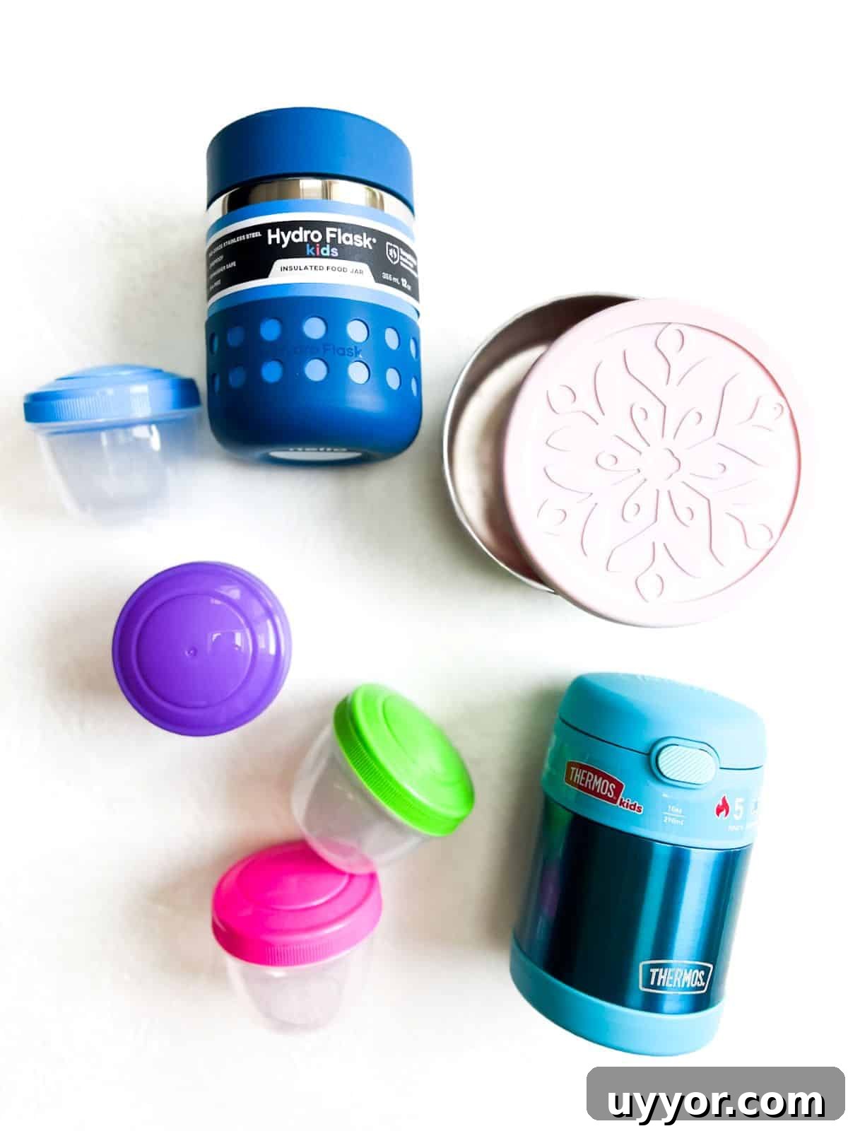 Top Lunch Containers for Work, School, and Meal Prep 2 Various colorful lunch containers with lids on a white surface.