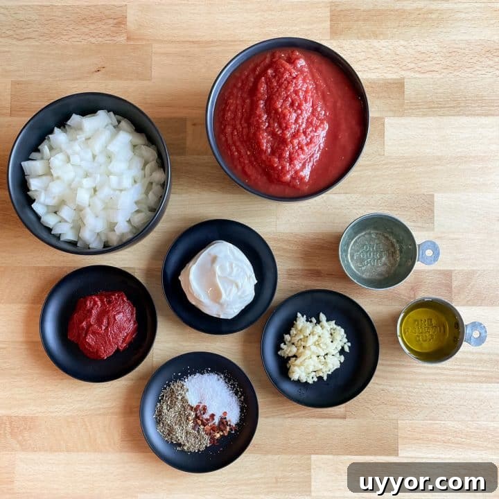 Two black bowls hold crushed tomatoes and diced onion; four small black plates hold mascarpone, tomato paste, minced garlic, and a spice mixture of Italian seasoning, salt, and red pepper flake; two small metal measuring cups hold white wine and olive oil. All ingredients are on a butcher block cutting board.
