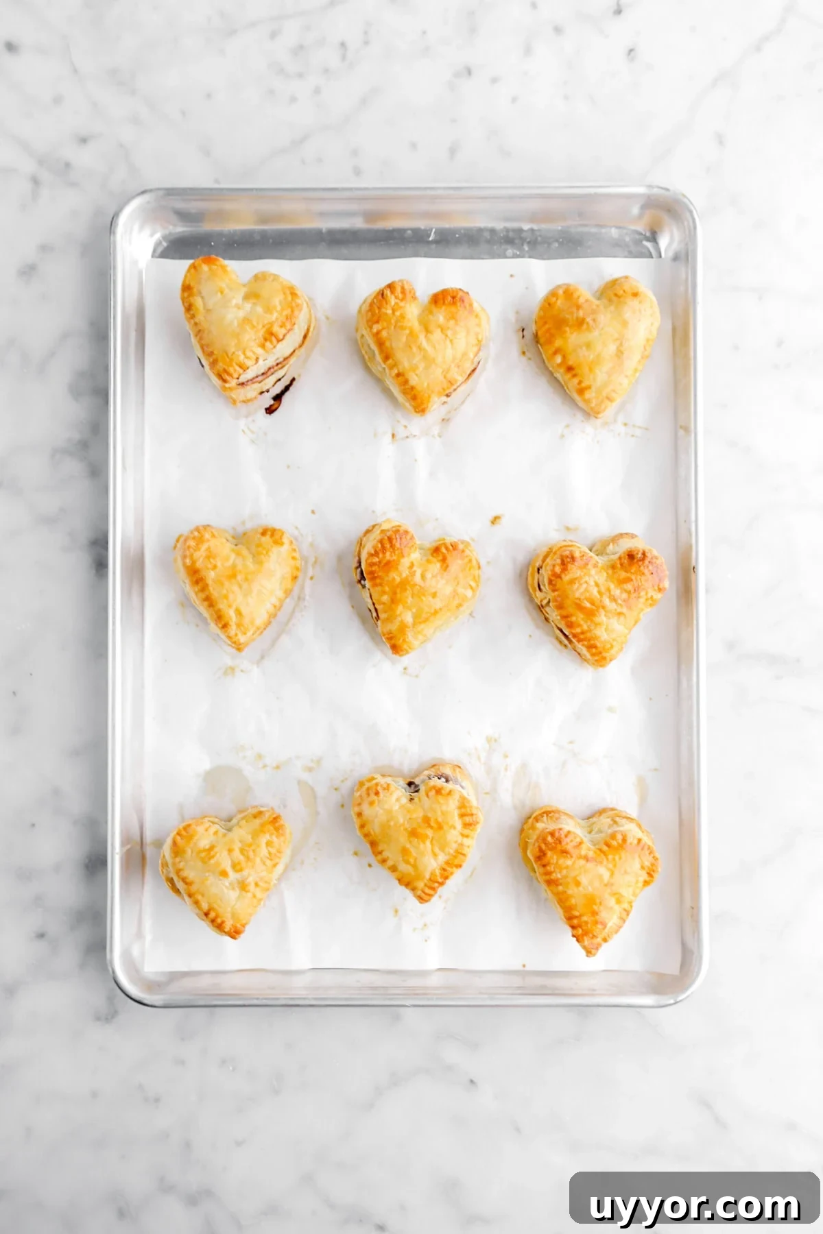 nine baked heart hand pies on sheet pan.