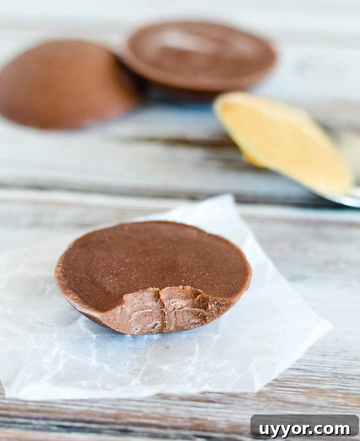 Chocolate Peanut Butter Fat Bombs. Easy fat bomb recipe for keto beginners. spoon of peanut butter, chocolate peanut butter keto fat bombs, one on waxed paper with a bite taken out of it