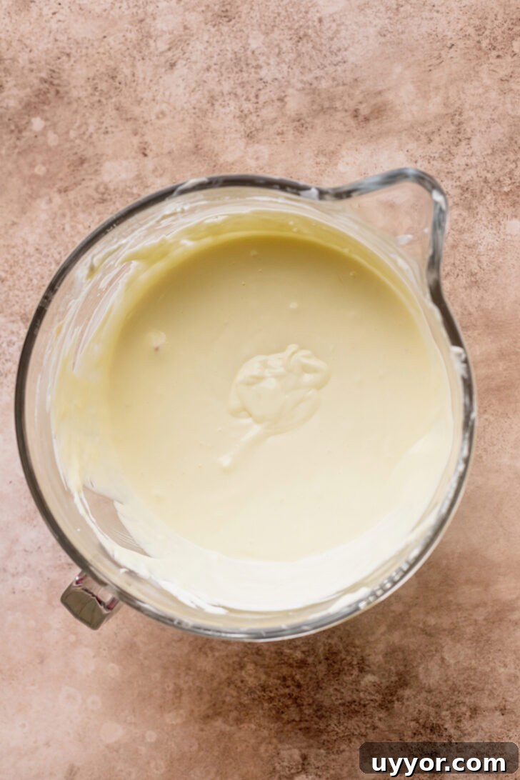 Cinnamon Roll Cheesecake Recipe: Swirled Cinnamon Cream Cheese Dessert 4 Cheesecake batter in a bowl.