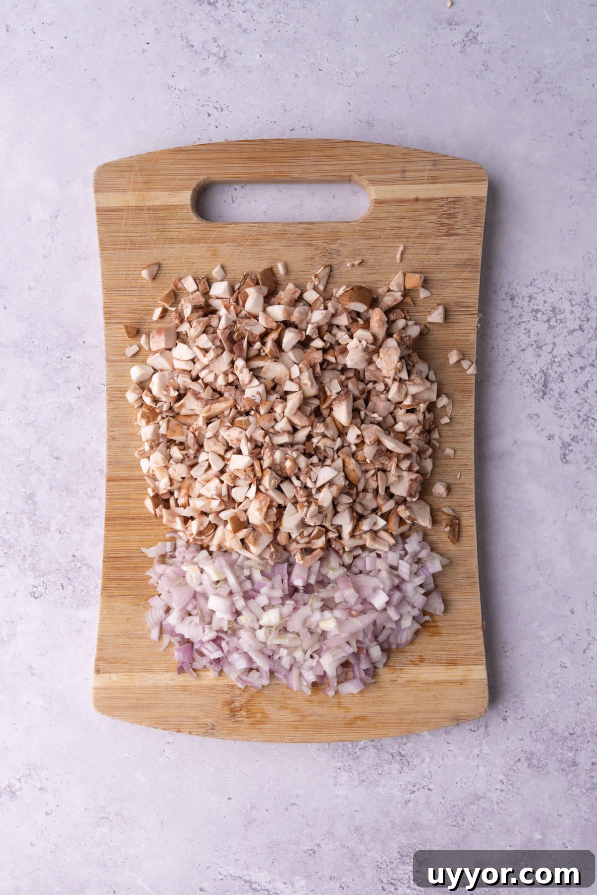 Creamy White Wine Mushroom Sauce Recipe for Pasta and Chicken 4 Diced mushroom and shallot on a wooden cutting board.