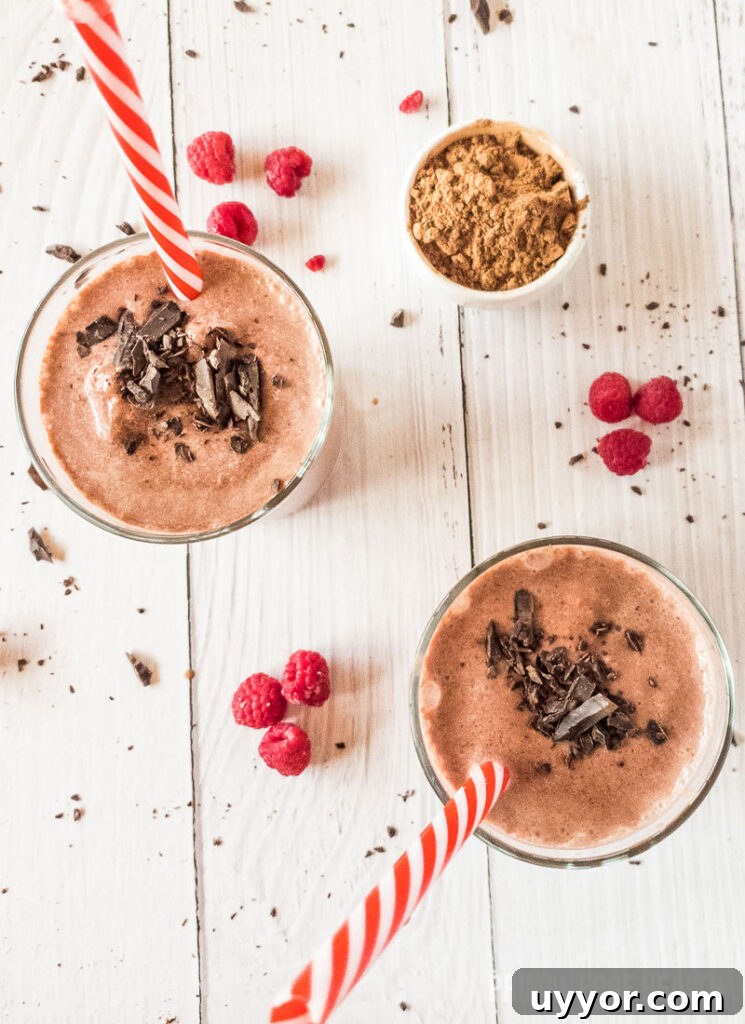 Two glasses of raspberry smoothie with chocolate toppings.