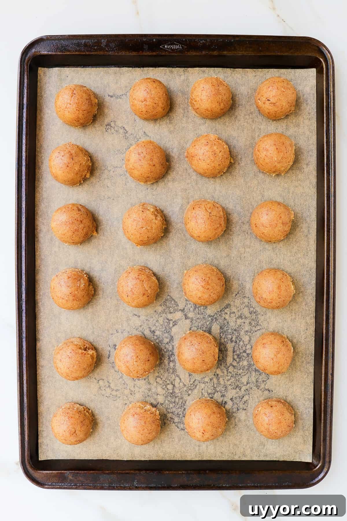 Cookie dough balls on baking tray.