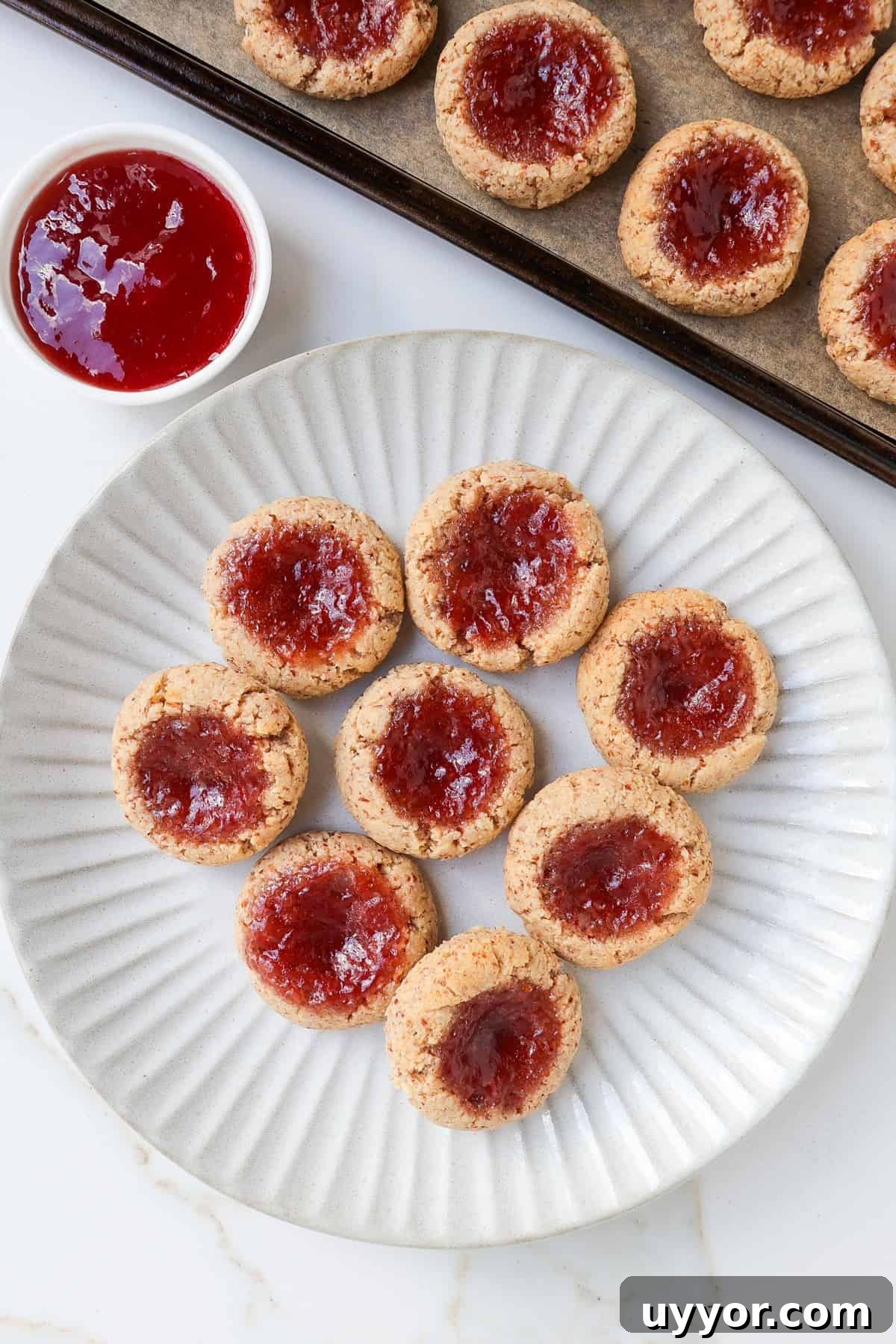 Strawberry jam thumbprint cookies on a plate.