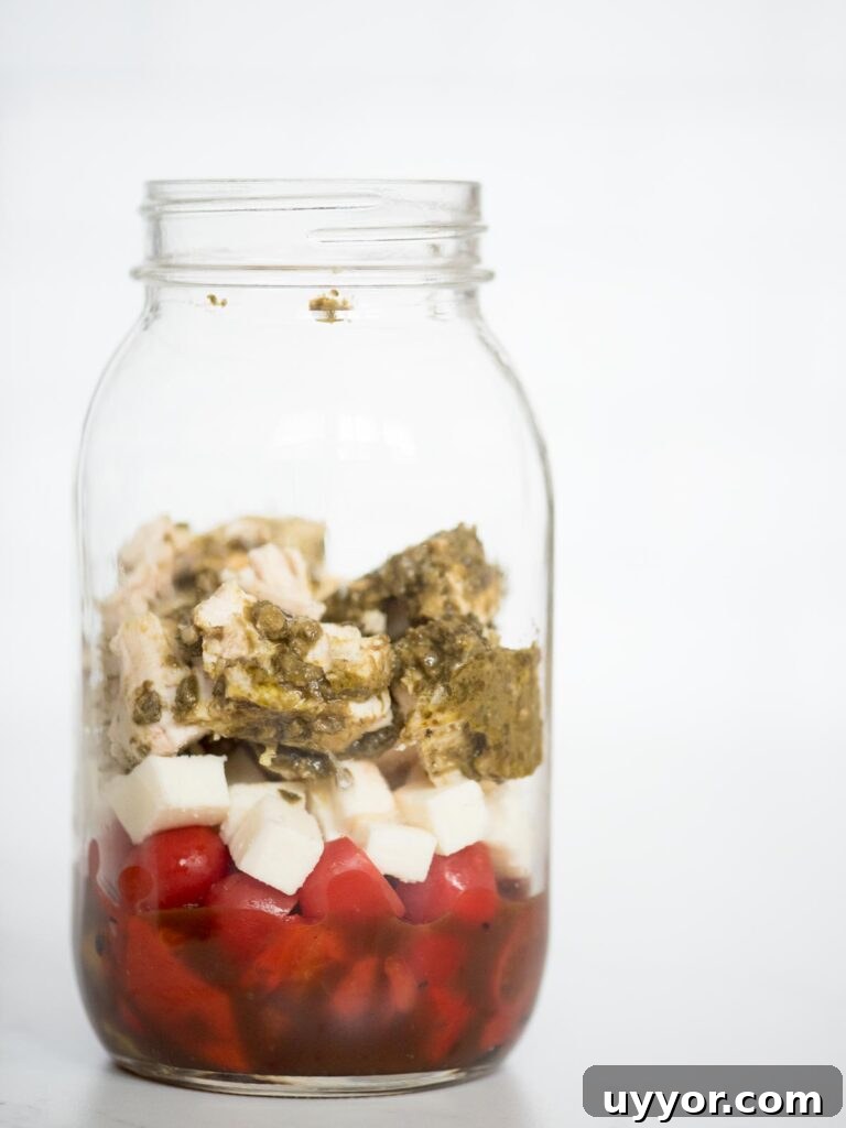 Pesto Chicken Mason Jar Salad Recipe for Meal Prep 8 balsamic vinaigrette, roasted peppers, grape tomatoes, basil pesto chicken, and mozzarella in a jar