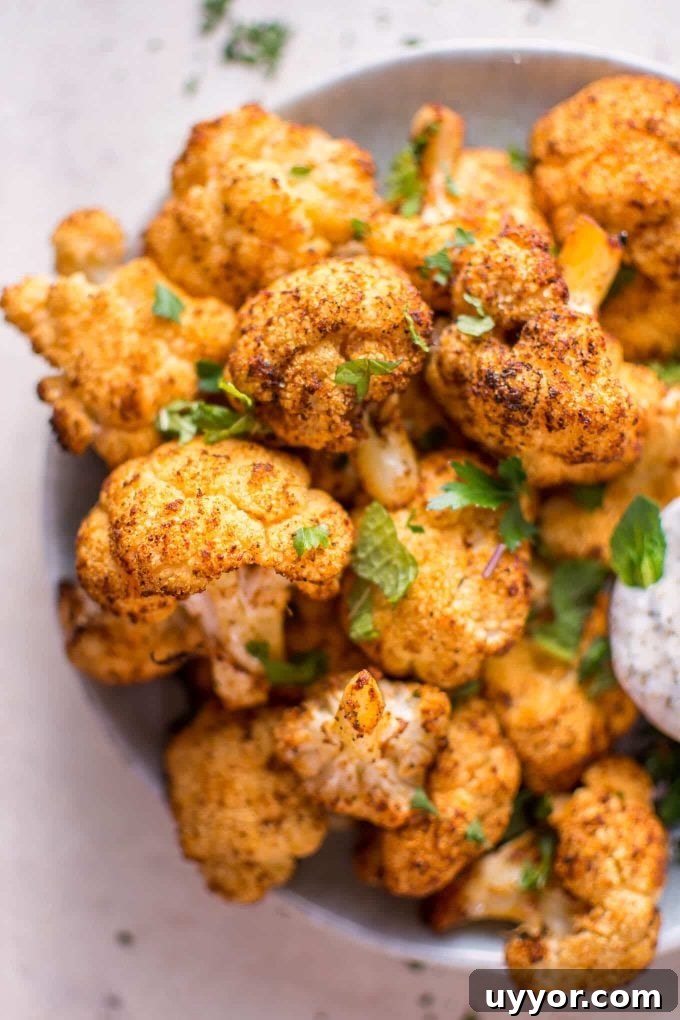 Roasted Cauliflower Bites with Cooling Mint Yogurt Dip 3 close-up of roasted cauliflower bites in a bowl garnished with mint
