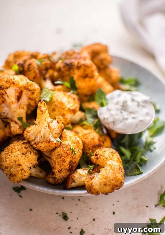 Roasted Cauliflower Bites with Cooling Mint Yogurt Dip 5 close-up of roasted cauliflower bites beside container of mint dip