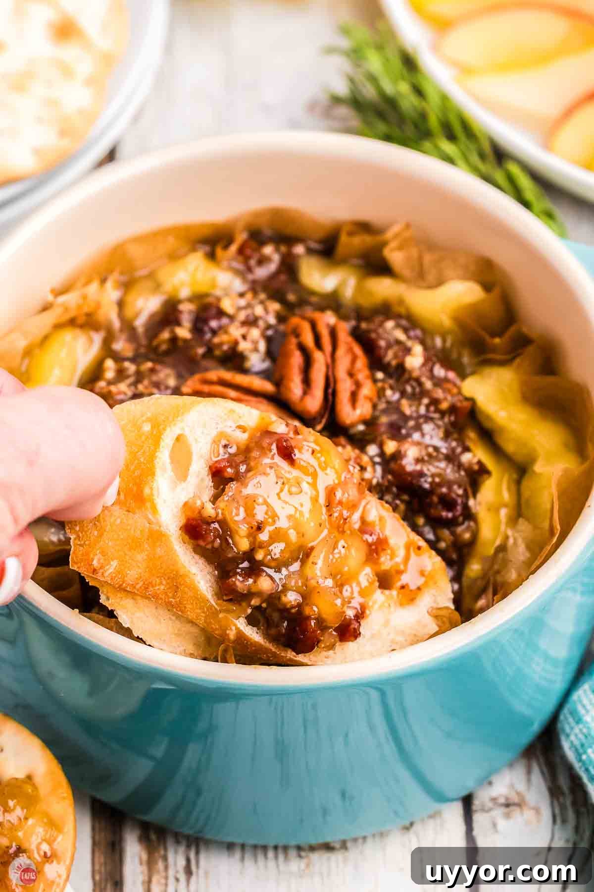 blue bowl with melted cheese and a crostini