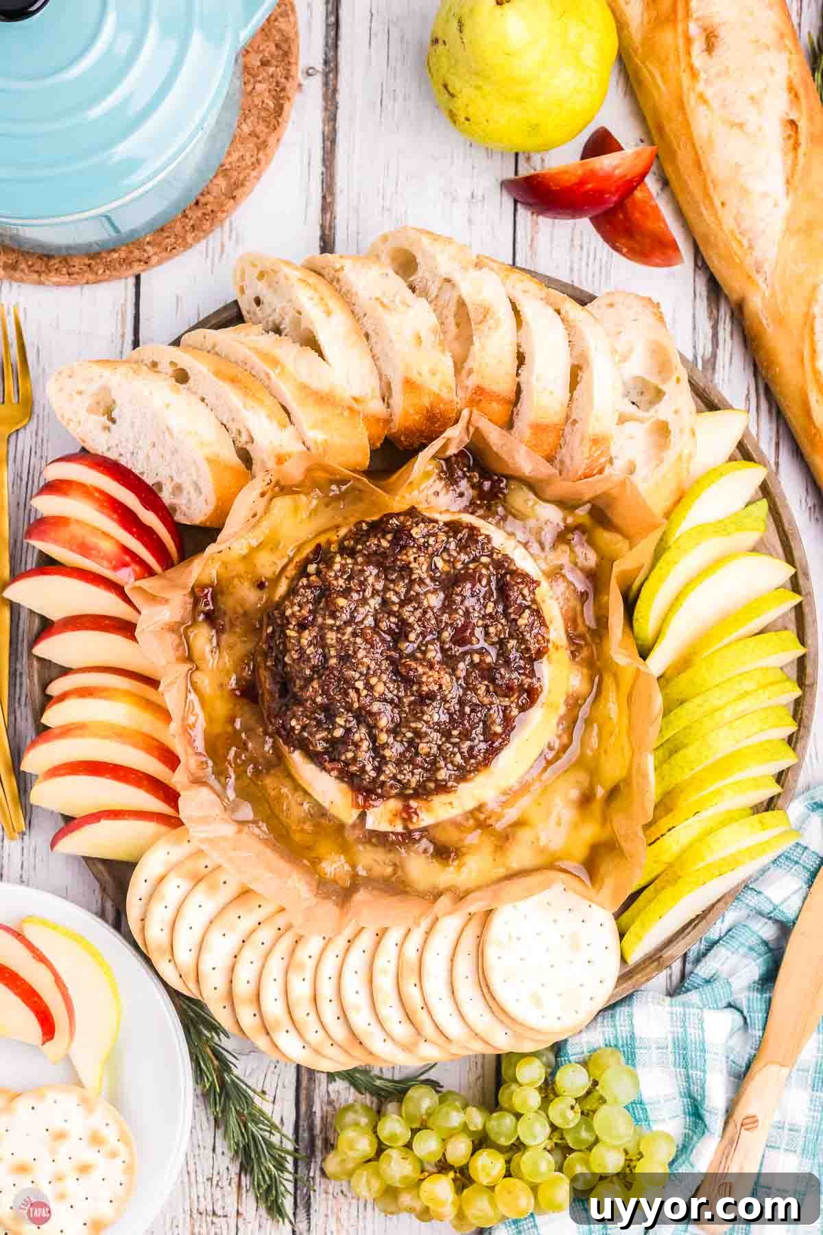 platter with baked brie, fruit slices and crackers