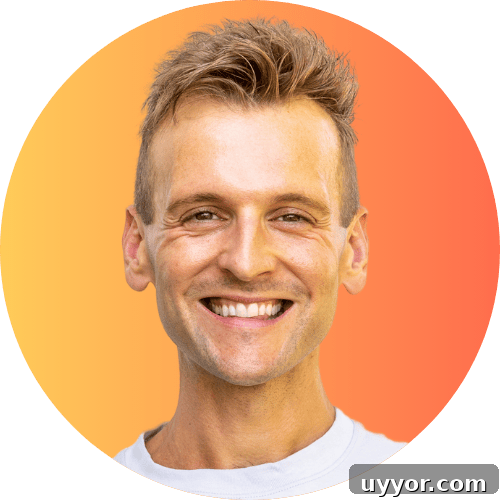 August 2024 Events, Deals & Planning Guide 2 Kaleb Wyse wearing gray shirt standing in front of an orange to yellow background smiling.