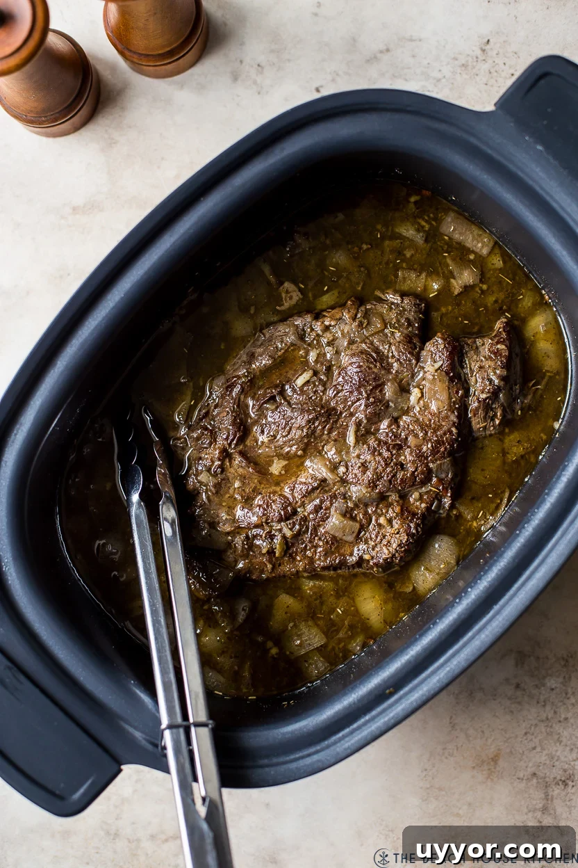 Slow Cooker Italian Beef Sandwiches with Tangy Au Jus 8 Overhead photo of cooked beef in a slow cooker