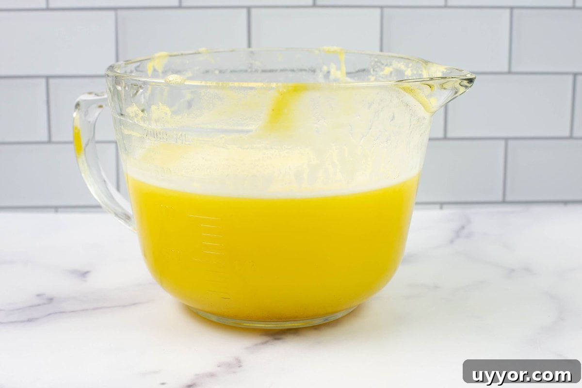 How to Preserve Pineapple by Canning: Step-by-Step Guide 4 Homemade Pineapple juice in a large clear measuring bowl.