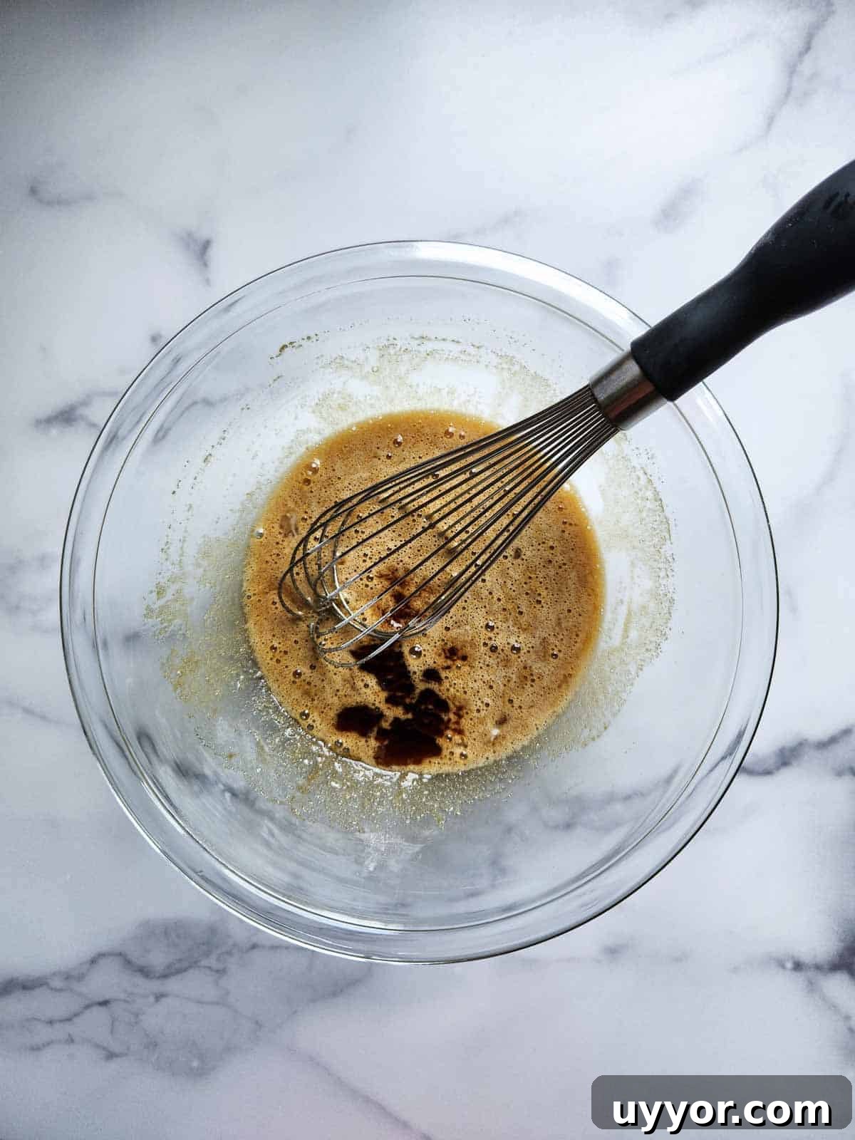 Bakery-Style Banana Bread with Pecans and Brown Butter Glaze 5 Whisking wet ingredients in a bowl.