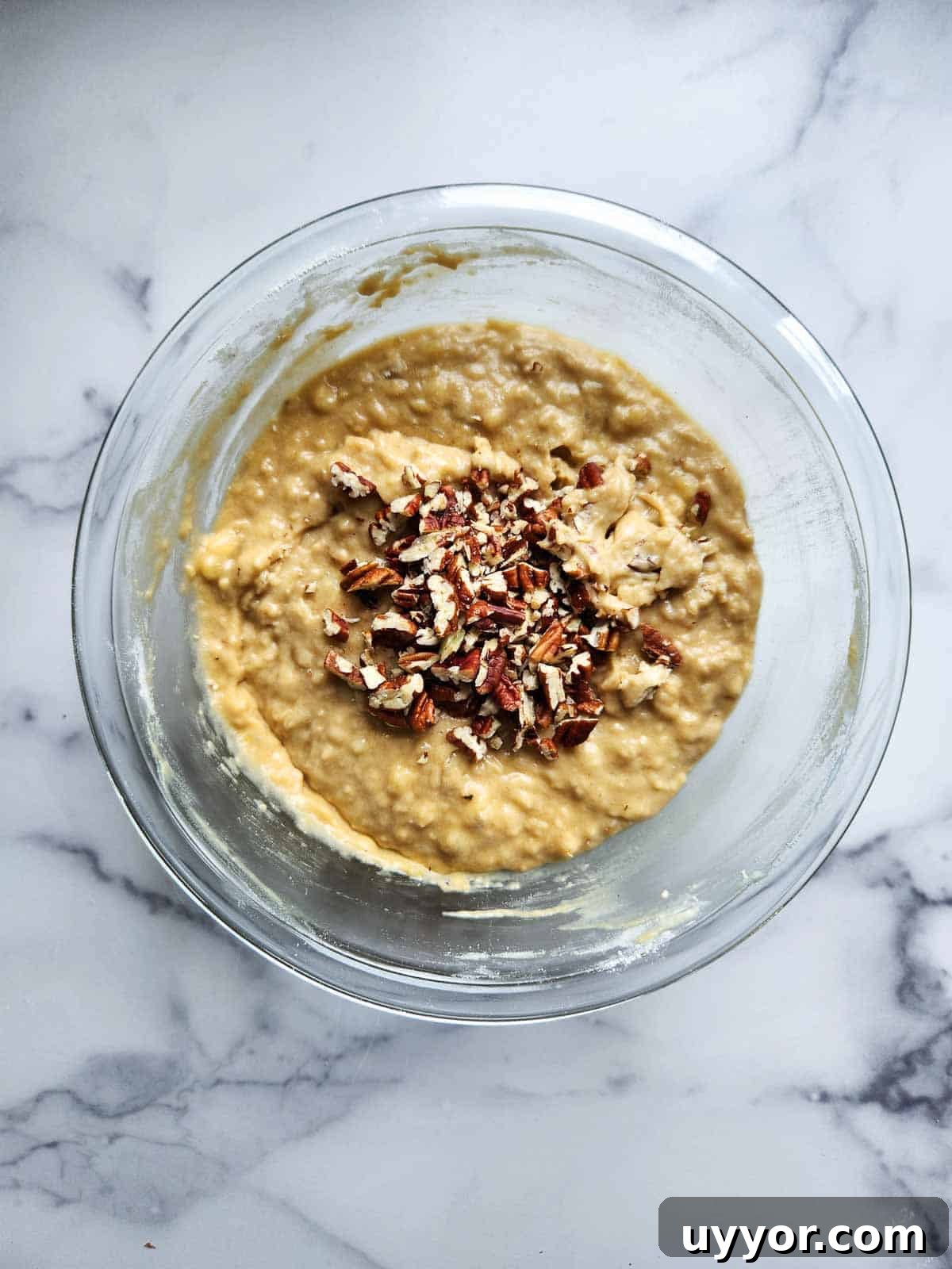 Bakery-Style Banana Bread with Pecans and Brown Butter Glaze 8 Pecans added to banana bread batter in a bowl.