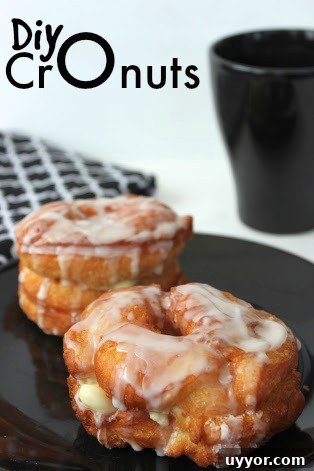 How to Make Cronuts at Home: Step-by-Step Recipe for Flaky, Custard-Filled Pastries 6 cronuts topped with glaze on a black plate.