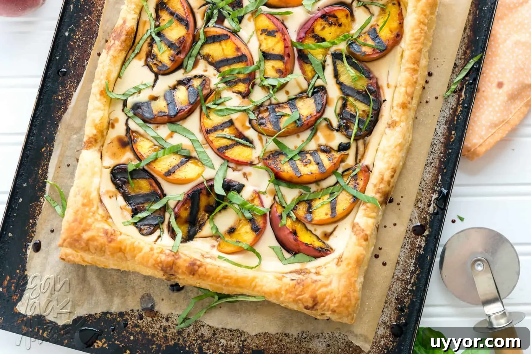Grilled peaches and cream pastry on a baking sheet lined with parchment paper