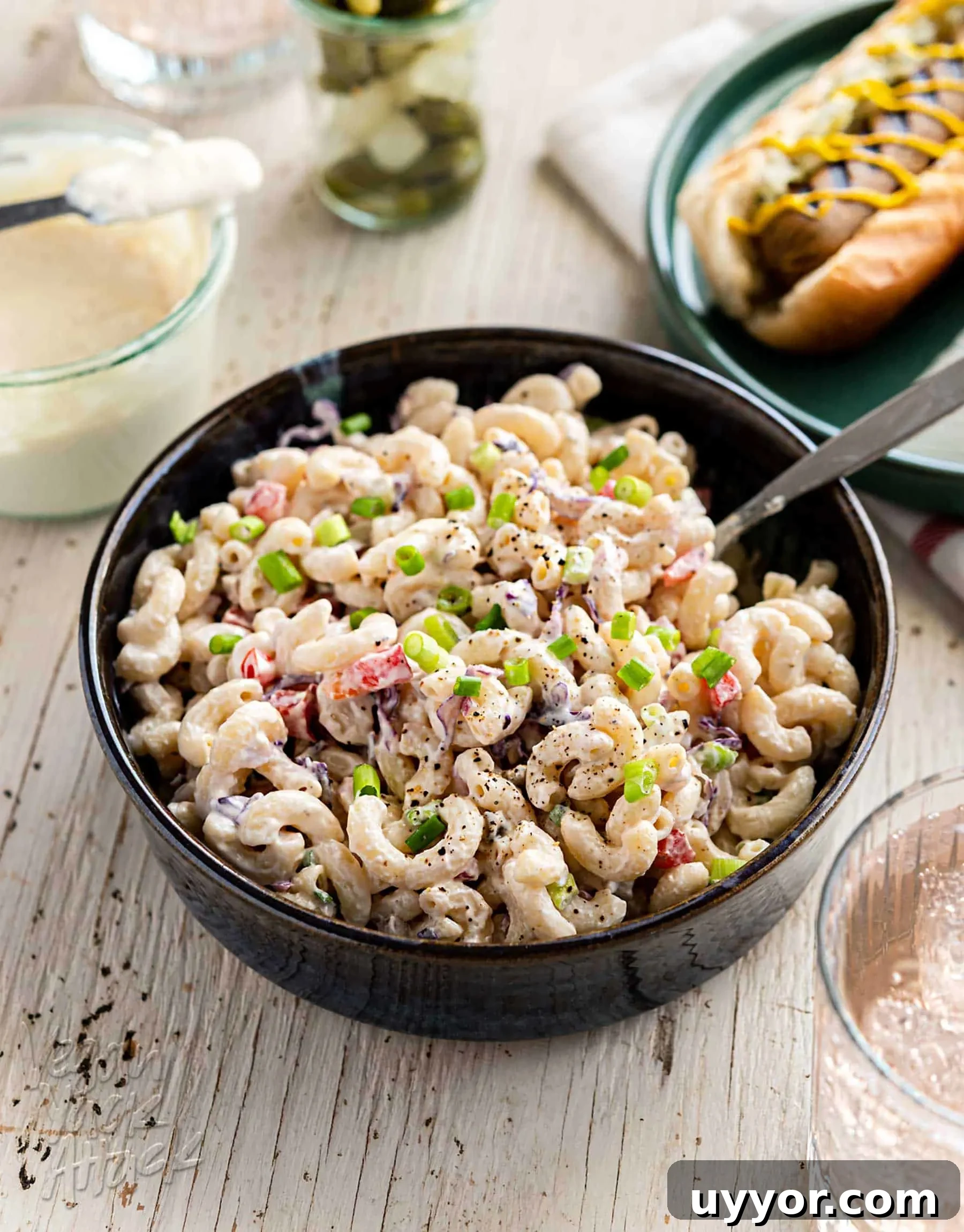 Large bowl of vegan macaroni salad on a white wood background