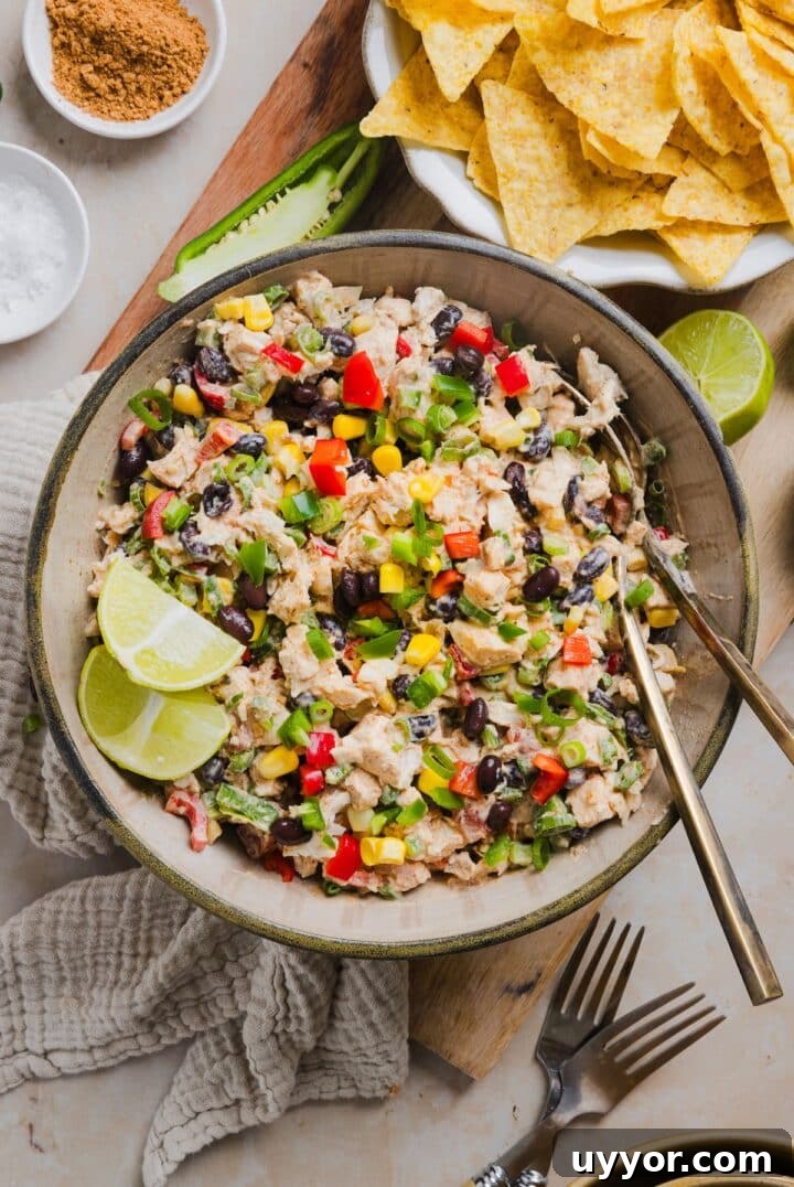 Southwest chicken salad in a serving bowl with lime wedges.