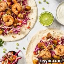 Spicy Shrimp Tacos with Caramelized Sweet Plantains 8 Spicy shrimp tacos with sweet plantains, tropical slaw, and lime crema on flour tortillas, garnished with cilantro and scallions.
