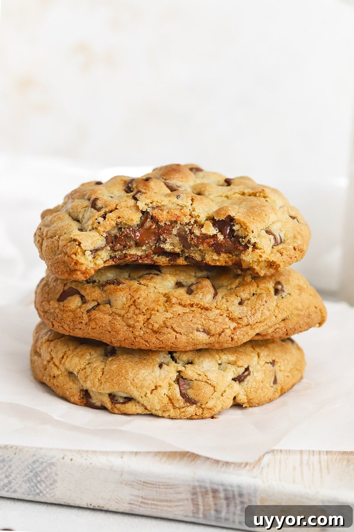 Gluten-Free Levain-Style Chocolate Chip Cookies 3 Front view of gluten-free Levain chocolate chip cookies stacked on top of each other, revealing a gooey middle
