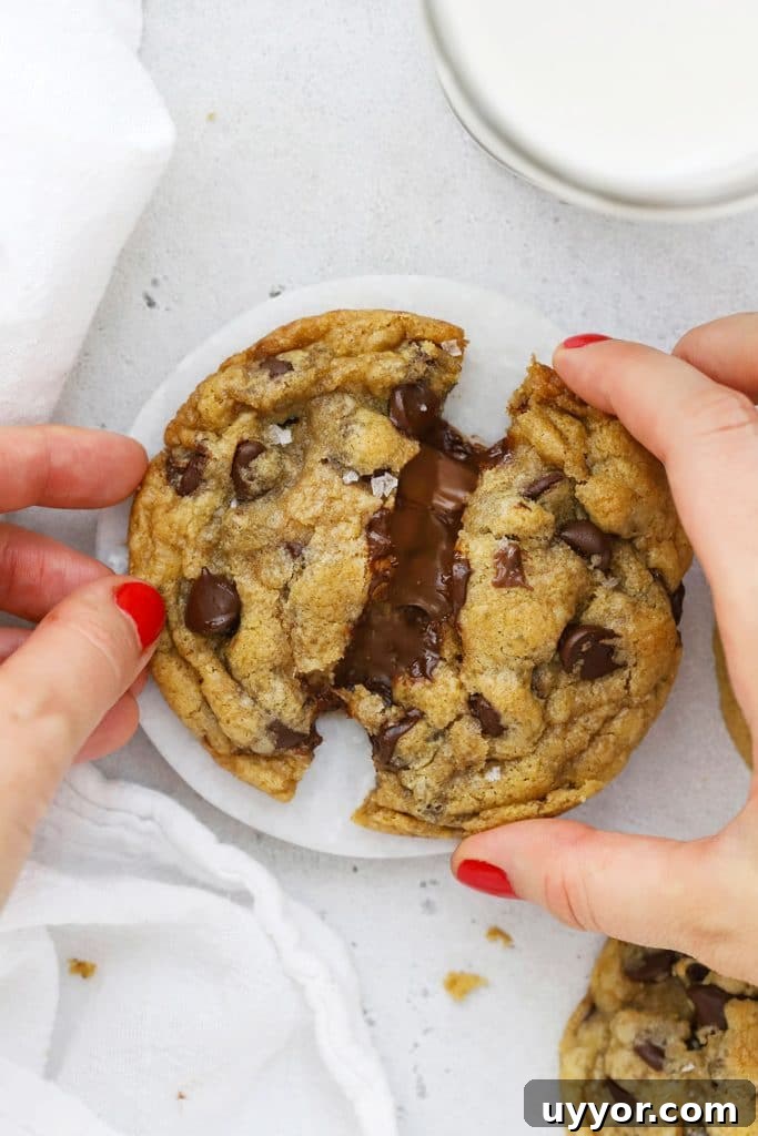Gluten-Free Levain-Style Chocolate Chip Cookies 10 Pulling apart a gluten-free Nutella chocolate chip cookie, revealing the gooey nutella center