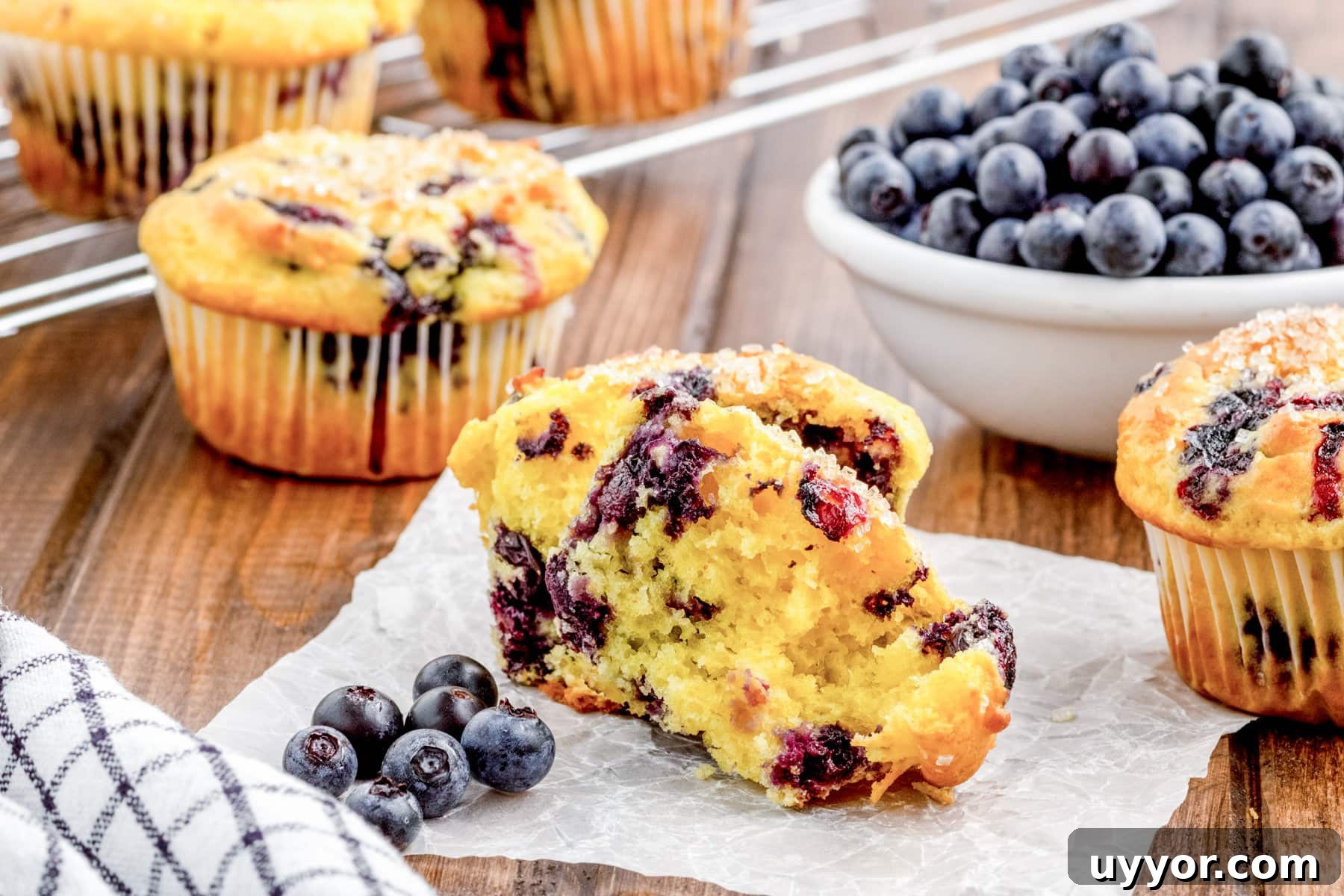 Blueberry Muffins from Cake Mix: Quick Homemade Recipe 8 Blueberry muffins, sliced in half, on a slice of parchment paper.
