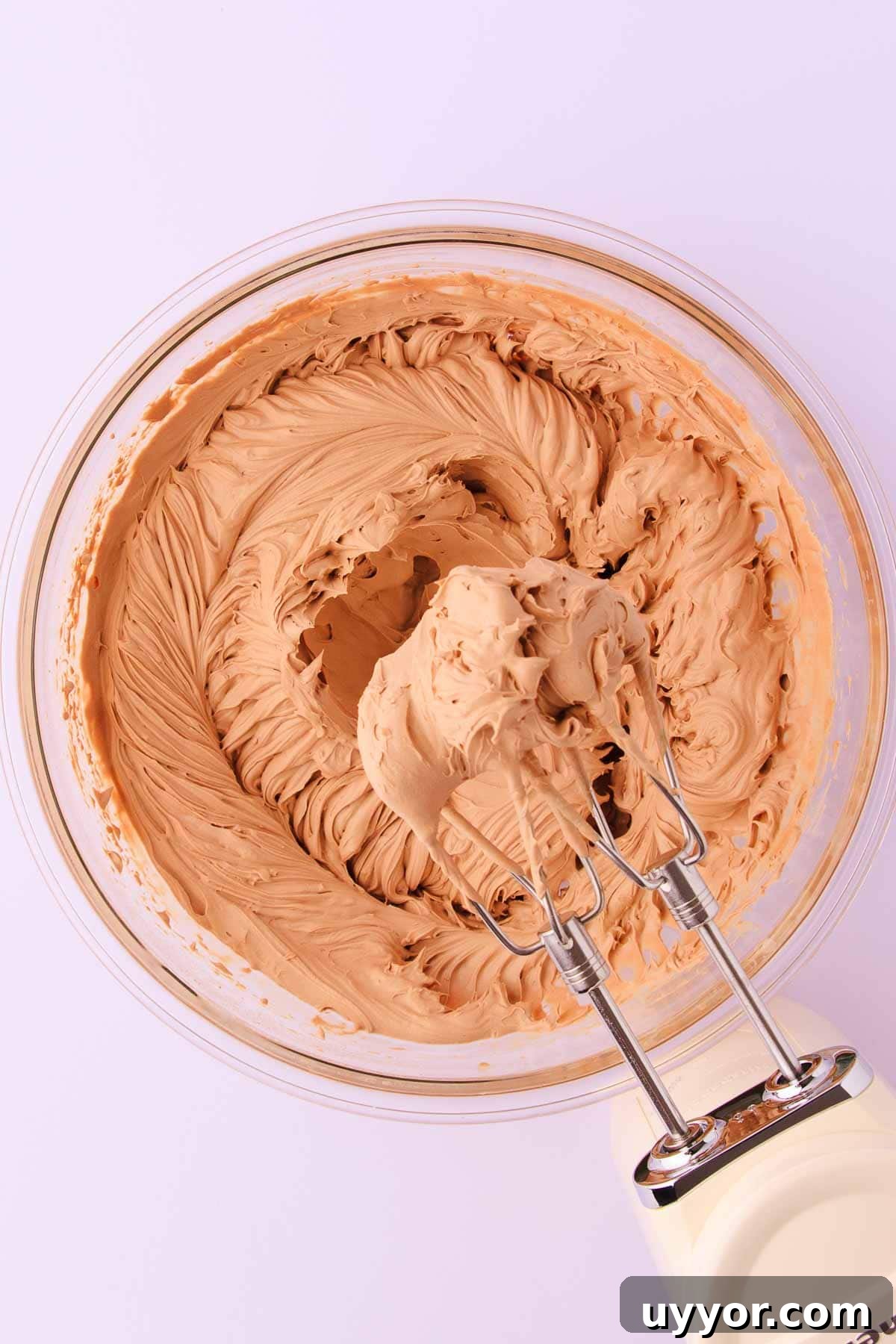 The whipped milk chocolate mousse, with a cream coloured kitchenaid electric hand mixer.