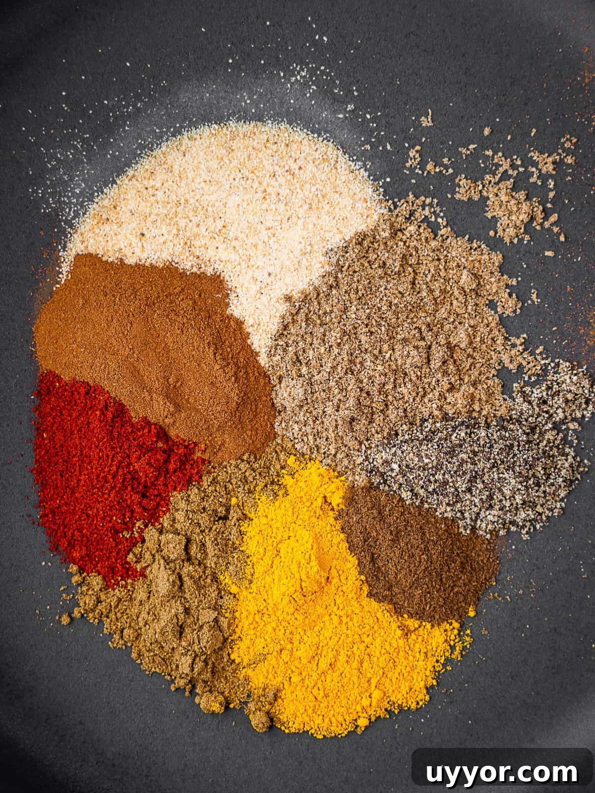 Individual spices on a plate before mixing.