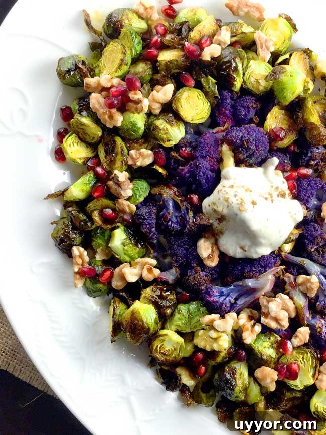 Crispy Roasted Brussels Sprouts with Pomegranate Molasses Glaze 5 roasted brussels sprouts with yogurt topping and purple cauliflower on a white plate