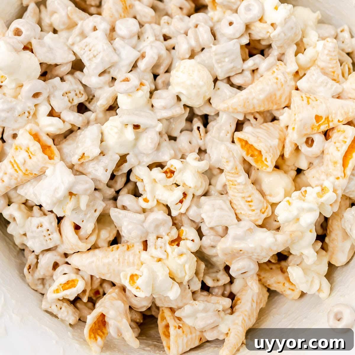 Patriotic Red White & Blue Chex Mix Recipe for 4th of July 6 Snack mix coated in candy coating in a white bowl.