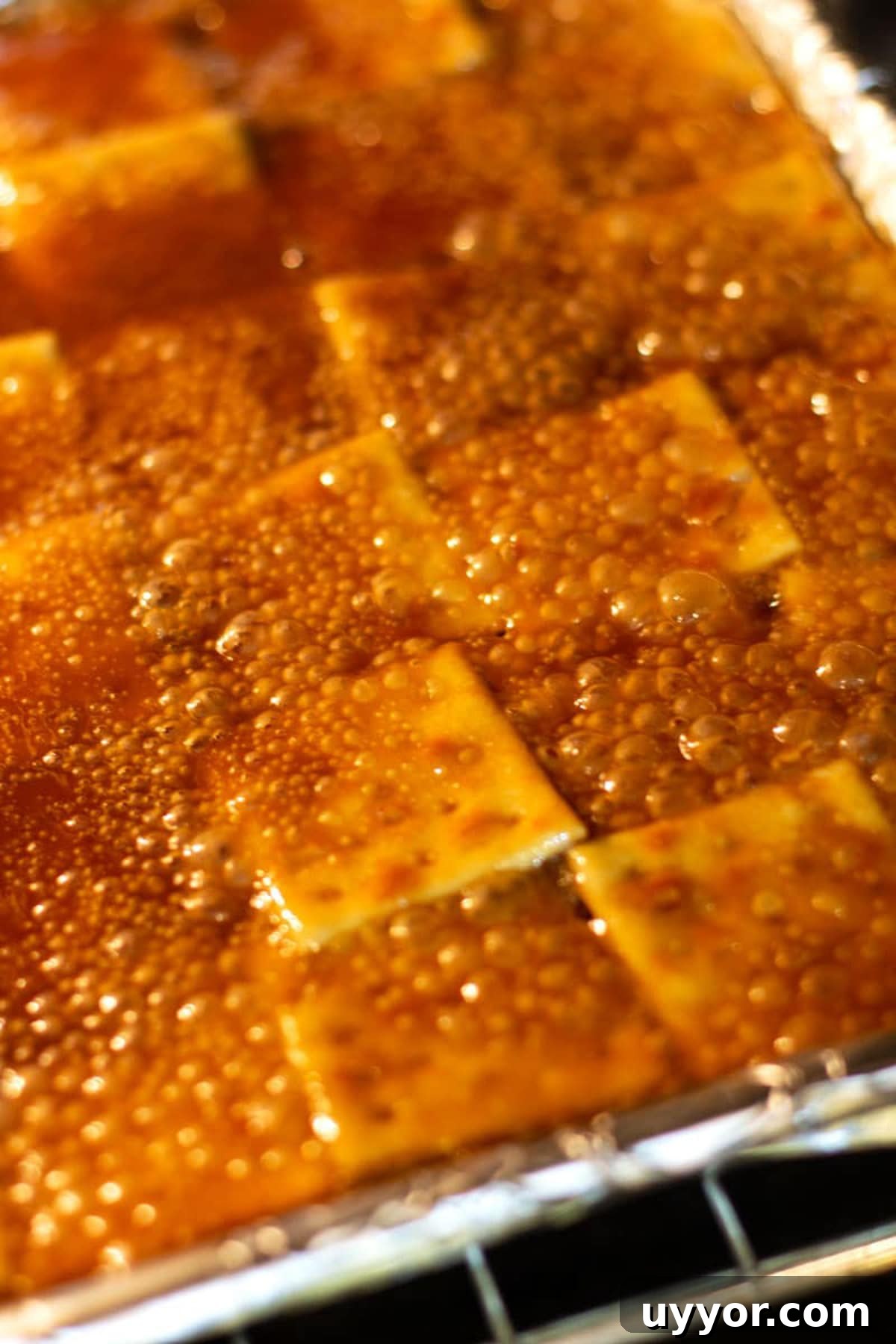Halloween Crack Candy Recipe: Sweet & Crunchy Toffee Treat 11 Caramel sauce bubbling in the oven over saltine crackers in preparation for making Halloween bark.