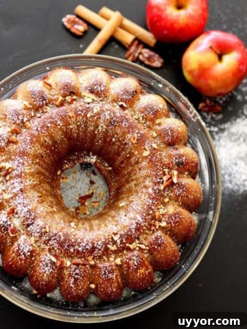 Apple pumpkin bundt cake sitting on a glass cake platter.