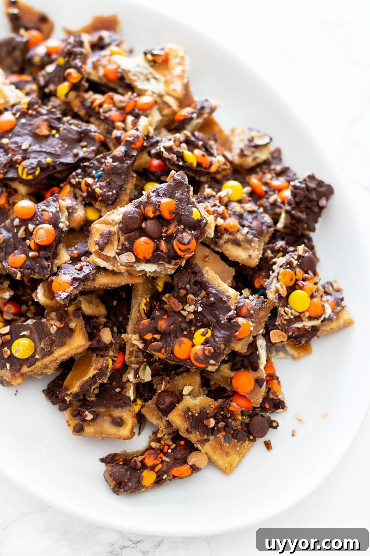 Halloween Crack Candy Recipe: Sweet & Crunchy Toffee Treat 3 Broken up pieces of cracker candy on a plate.