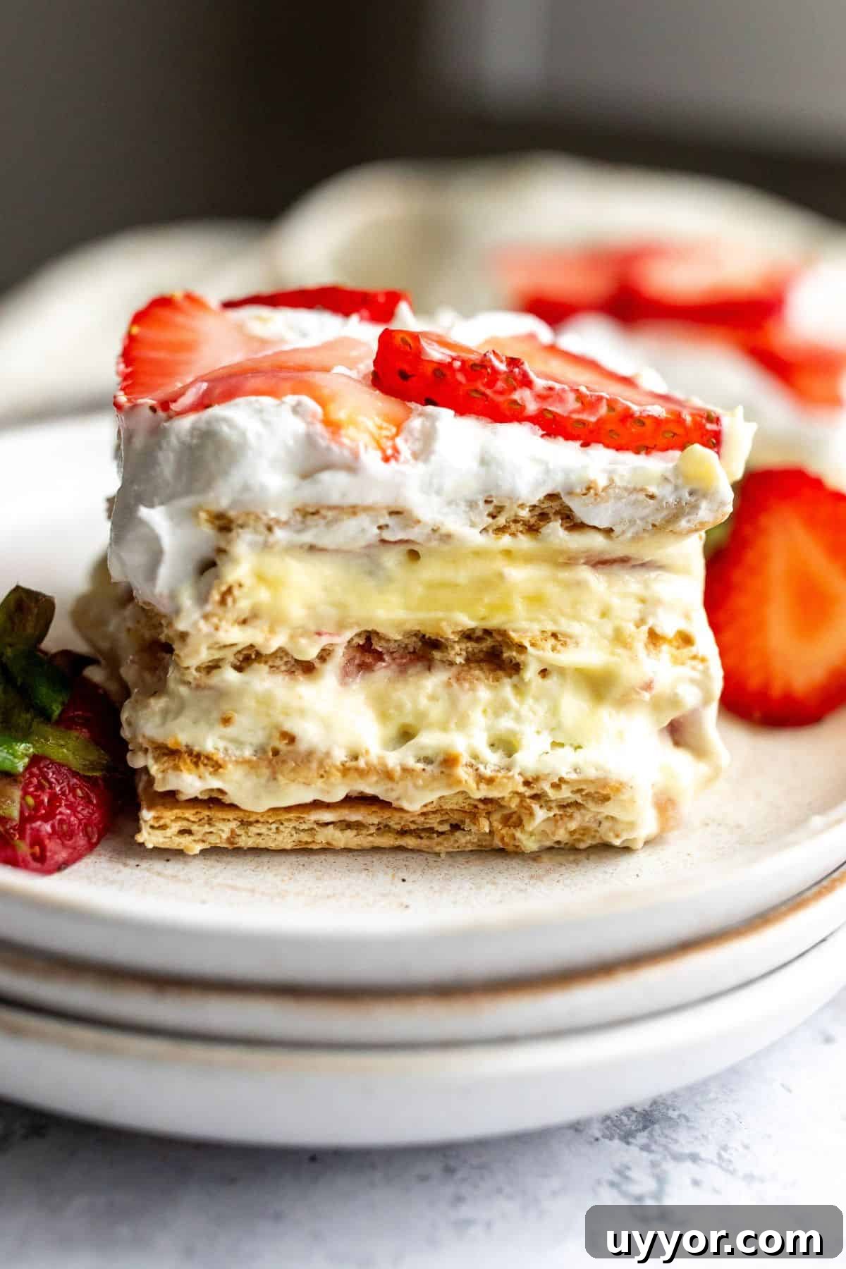 Strawberry Icebox Cake on several white plates with a silver fork.