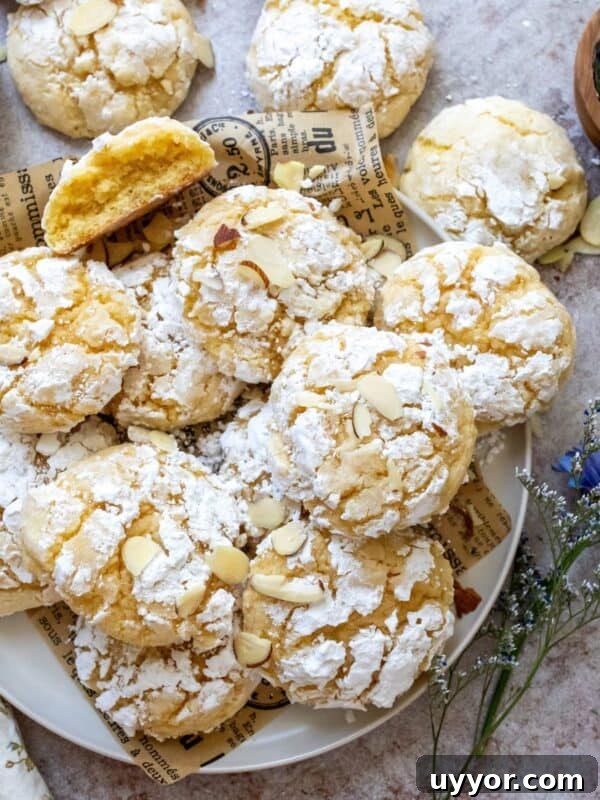 lemon almond cookies with crinkles on a white plate.