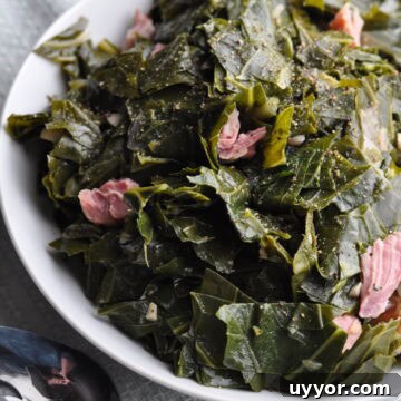Southern Collard Greens with Ham Hock Recipe for Authentic Flavor 11 Collard greens with ham in small bowl with spoon ready to serve.