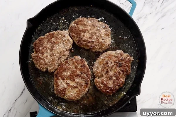 Salisbury Steak with Savory Mushroom and Onion Gravy 4 Seared beef patties in a skillet