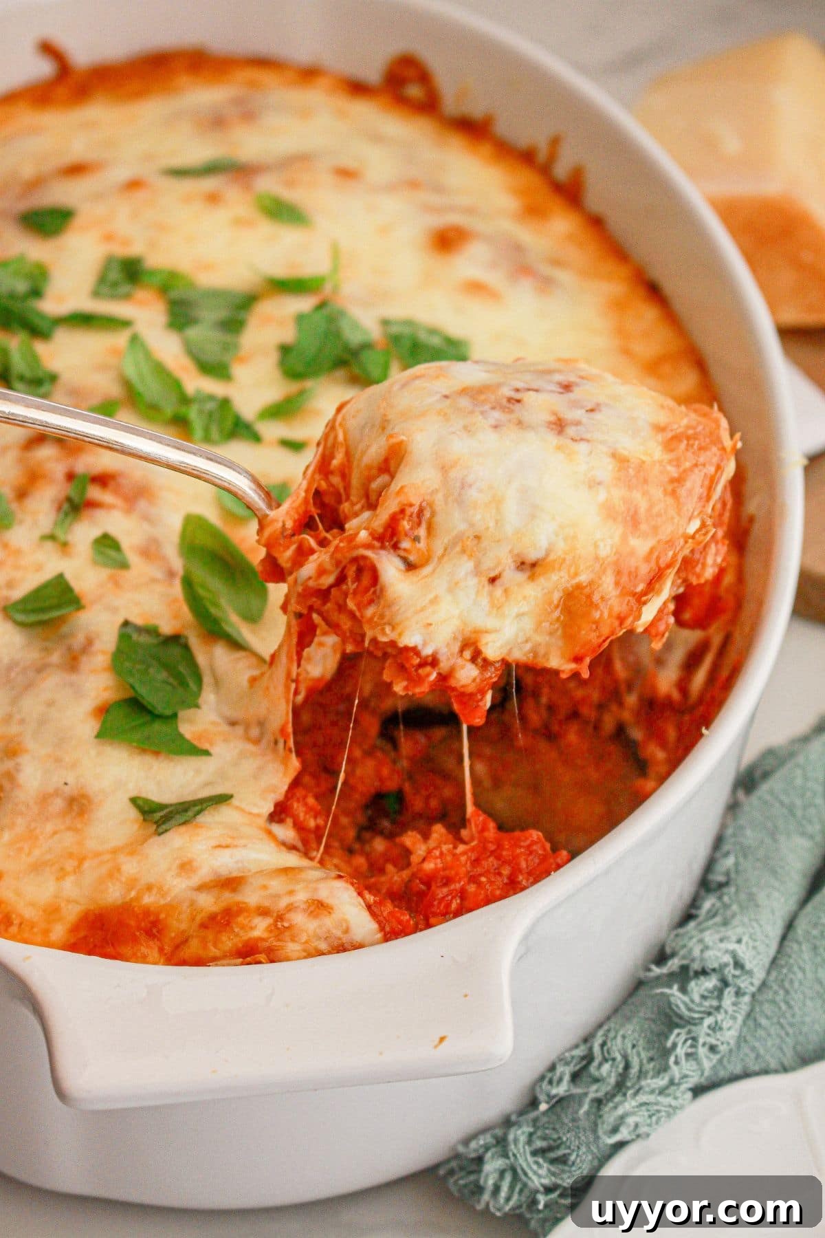 Classic Homemade Eggplant Parmesan Recipe for Crispy Layers 3 Scoop of eggplant parmesan being removed from a baking dish.